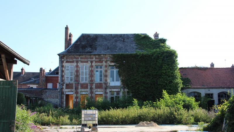 Vue de derrière, la maison de maitre expose ses plus beaux atours. L’autre facade est recouverte de béton.