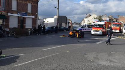 Le motard pris en charge par les secours, avec, à gauche, la roue avant de sa moto.